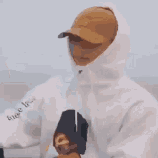a man in a hat is holding a yellow object in his hand while another man looks on .
