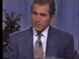 a man in a suit and tie is giving a speech on a television show .