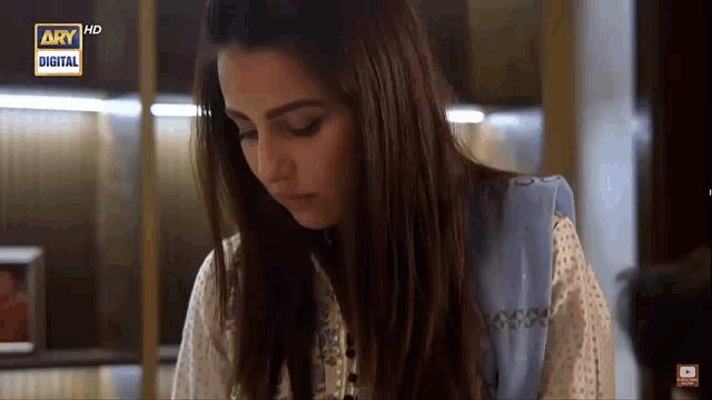 a woman is sitting in front of a screen that says ary hd