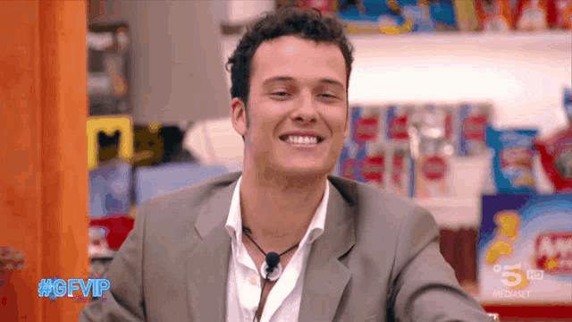 a man is smiling in front of a sign that says #gfvip on it