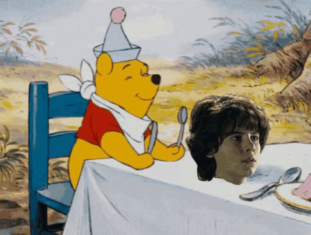 winnie the pooh is sitting at a table with a spoon and fork