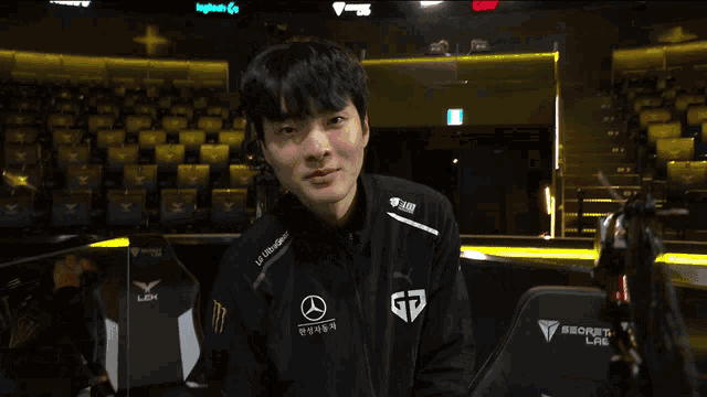 a young man wearing a black jacket with mercedes benz on it