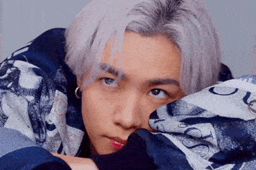 a close up of a person 's face with a blue and white shirt on