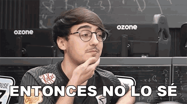 a man wearing glasses and a kitkat shirt says " entonces no lo se " in spanish