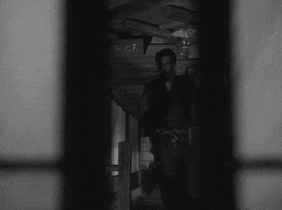 a black and white photo of a man in a hallway