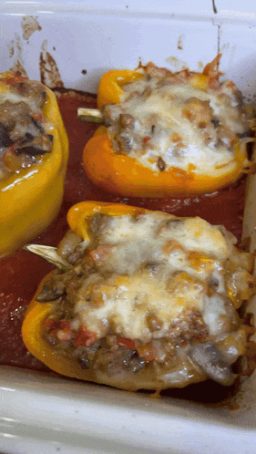 a casserole dish filled with stuffed peppers covered in sauce and cheese