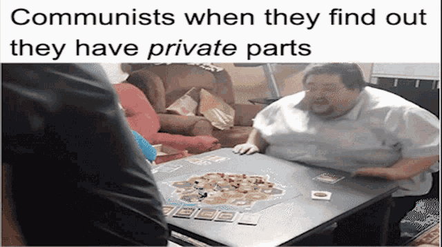 a man sits at a table playing a board game with a caption that says communists