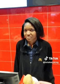 a woman in a mcdonald 's uniform is holding a plate of fries .