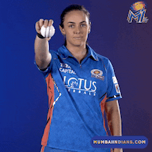 a woman wearing a blue shirt that says lotus is holding a ball