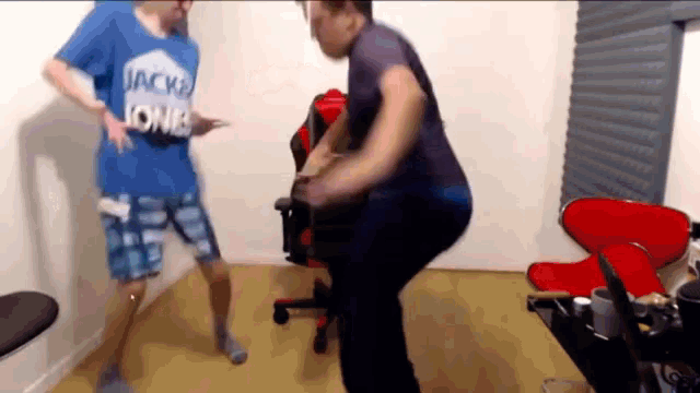two men are dancing in a room with one wearing a blue shirt that says jack jones
