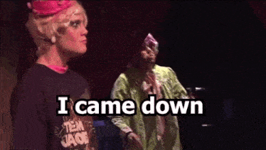 a man and a woman are standing on a stage with the words `` i came down '' written on the screen .