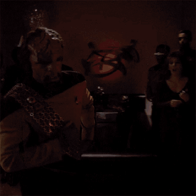 a man in a star trek uniform is standing in front of a group of people