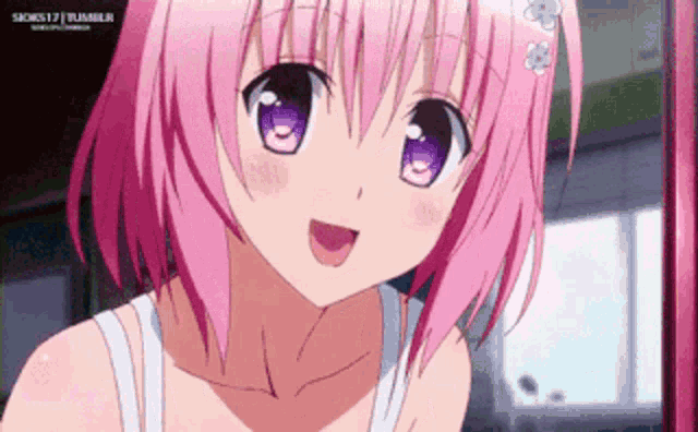 a girl with pink hair and purple eyes is smiling and looking at the camera .