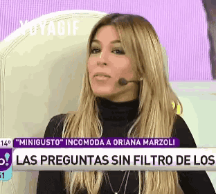 a woman in a black turtleneck is sitting in front of a sign that says las preguntas sin filtro de los