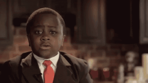 a young boy in a suit and tie is standing in front of a sign that says ten