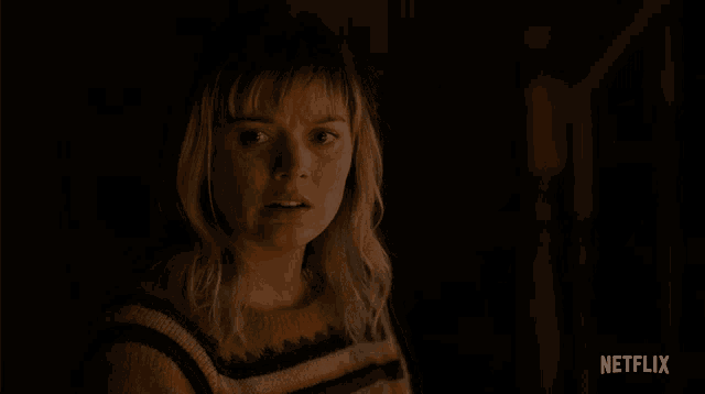 a woman in a yellow and black striped sweater has a netflix logo above her