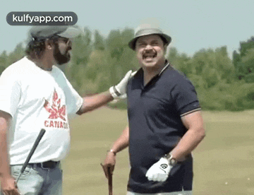 two men are standing next to each other on a golf course and talking to each other .