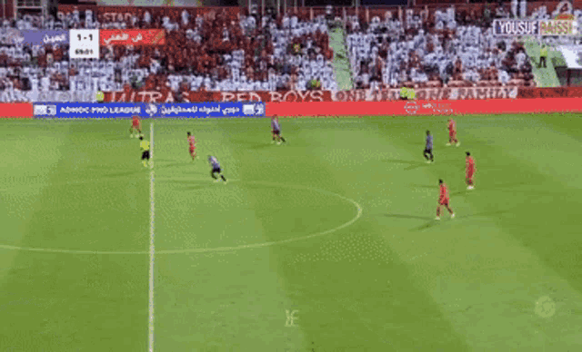 a soccer game is being played on a field with a sign that says yousuf assisi