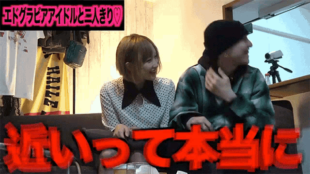 a man and a woman are sitting on a couch in front of a sign that says ' really ' on it