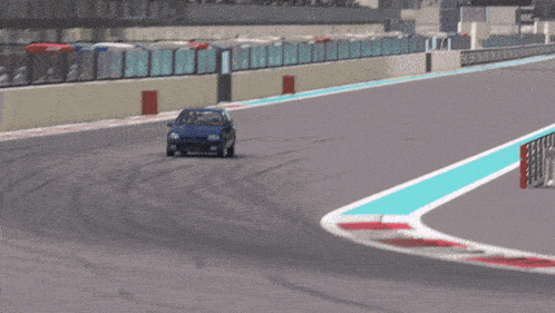 a blue car is driving on a track with a blue line