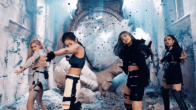 a group of girls are dancing in front of a statue in a room .