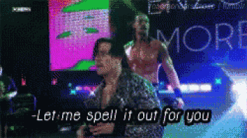 a man and a woman are dancing in front of a sign that says - let me spell it out for you