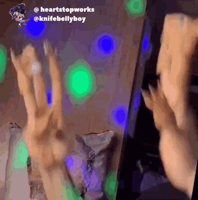 a gif of a person holding a cell phone with the words " heartstopworks @knifebellyboy " at the top