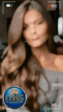 a woman is being recorded on a camera with a mks logo on the bottom