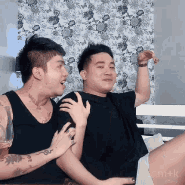 a man with a tattoo on his arm holds another man