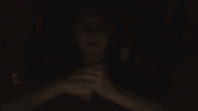 a person holding another person 's hands in the dark