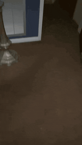 a black laundry basket sits on the floor in a living room