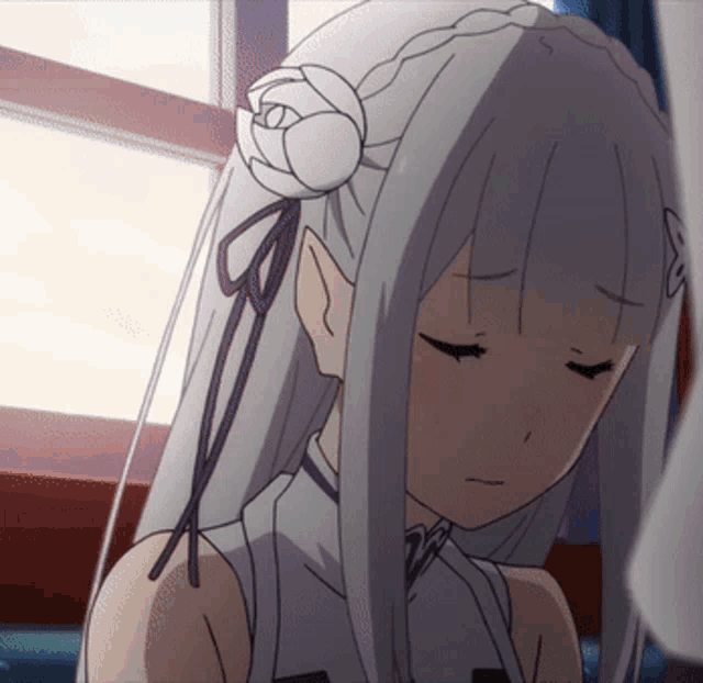 a girl with a flower in her hair is looking down