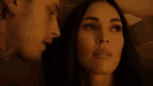 a man and a woman are kissing in a dark room and the woman is saying `` no '' .