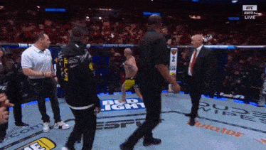 a man in a black shirt with the number 2 on it stands in a boxing ring