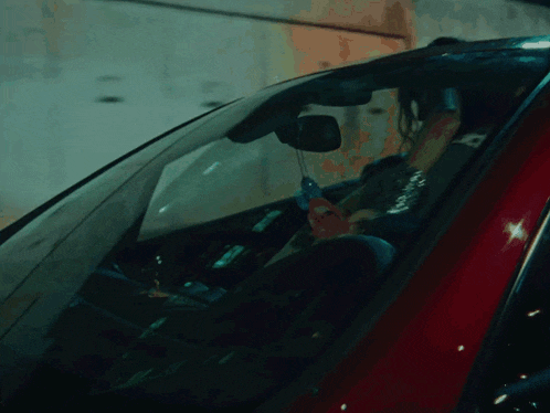 a woman is sitting in the back seat of a car with the number 55 on the back