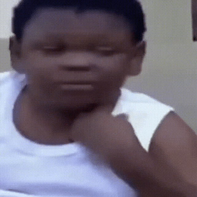 a man in a white tank top is making a funny face .