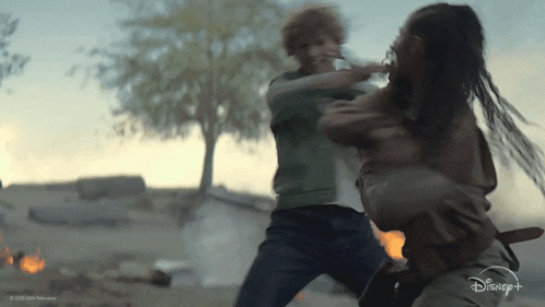 a man and a woman are fighting in a scene from a disney + show