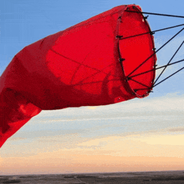 a red wind sock is being blown in the wind