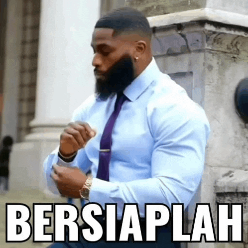 a man with a beard is wearing a blue shirt and a purple tie .