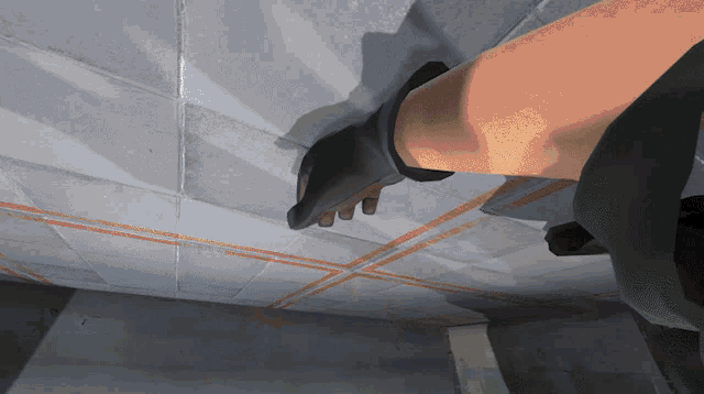 a person wearing a glove is standing on a concrete floor