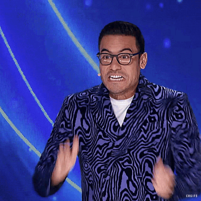 a man wearing glasses and a zebra print jacket is making a face