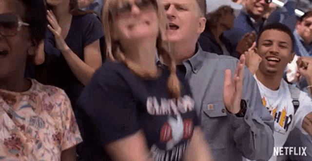 a woman is dancing in a crowd of people at a concert .