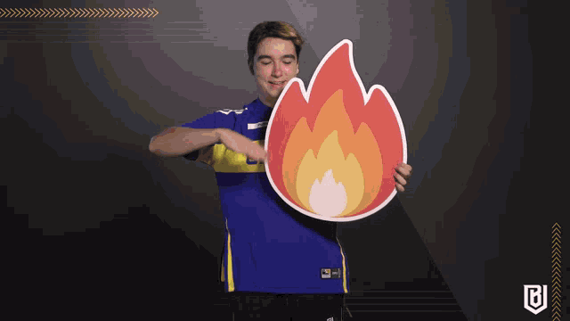 a man in a blue and yellow shirt is holding a flame sticker