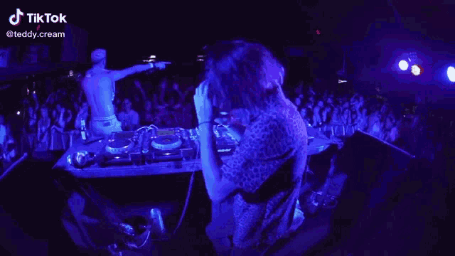 a man playing a dj set in front of a crowd with a tik tok watermark