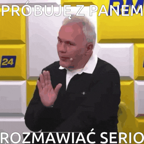 a man waving his hand in front of a wall that says 24 on it