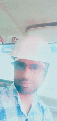 a man is wearing a hard hat and sunglasses