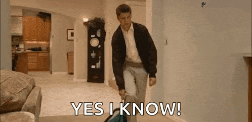 a man is walking through a living room carrying a suitcase and says `` yes i know '' .
