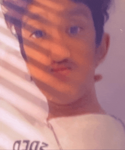 a close up of a person 's face with a shadow on the wall
