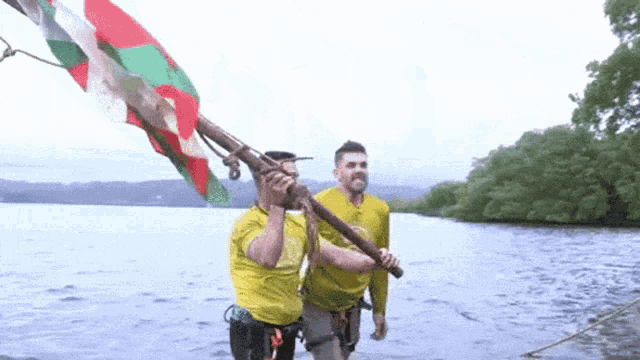 a man in a yellow shirt is holding a flag