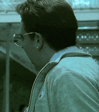 a close up of a person wearing glasses and ear piercings